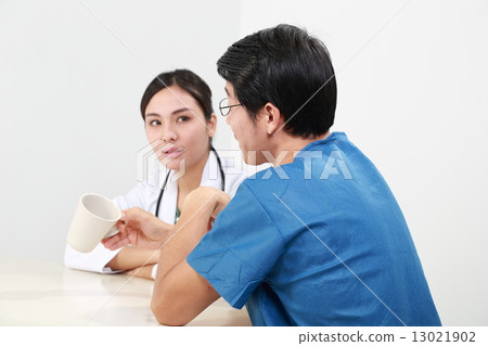 Male and female doctor in uniform take break discuss  13021902