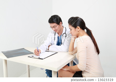 Male doctor explains to female patient Male doctor explains to female patient 13023319