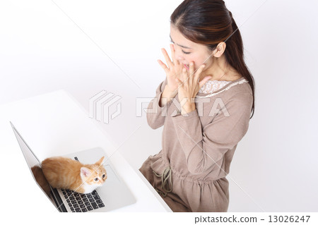 一個女人因為小貓在個人電腦上而感到驚訝 一個女人因為小貓在個人電腦上而感到驚訝 13026247