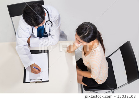 Doctor discussing with patient over medical condition 13032108