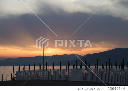 man and woman whiile kissing on sestri levante beach at sunset 13044344