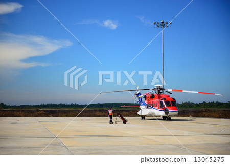 fireman is guarding for helicopter before start up engine 13045275