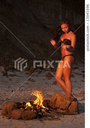 Beautiful woman near the fire on the beach Beautiful woman near the fire on the beach 13045896