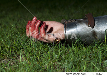 Bloody hand lying on the grass and holding ring Bloody hand lying on the grass and holding ring 13046629