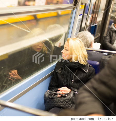 Woman looking out metro's window. 13049107
