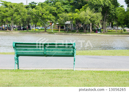 bench in park by a pond in the background, thailand 13056265