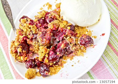 Crumble cherry in plate with spoon on tablecloth 13057194