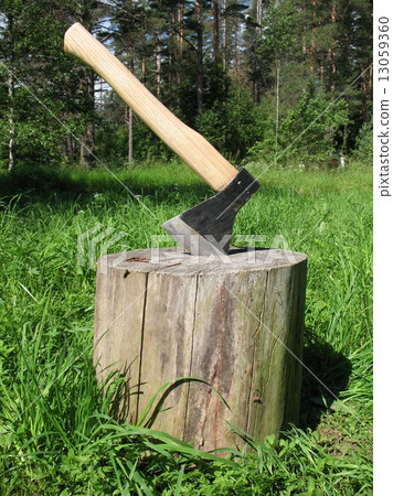 Ax stuck in a block of wood Ax stuck in a block of wood 13059360