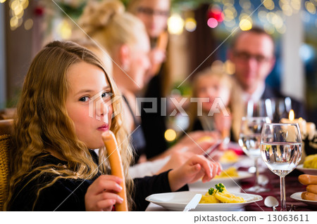 Family eating Christmas sausages for dinner Family eating Christmas sausages for dinner 13063611