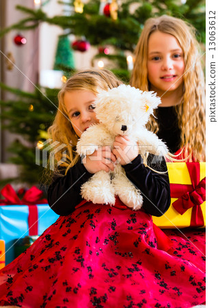 Children receiving presents on Christmas day Children receiving presents on Christmas day 13063612