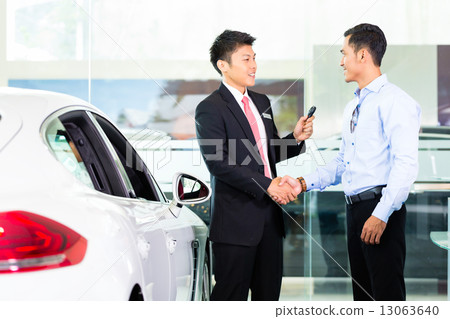 Asian Car Salesman selling auto to customer 13063640