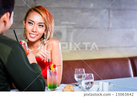 Asian couple drinking cocktails in fancy bar 13063642