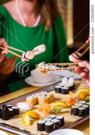 Young people eating sushi in Asian restaurant Young people eating sushi in Asian restaurant 13064005