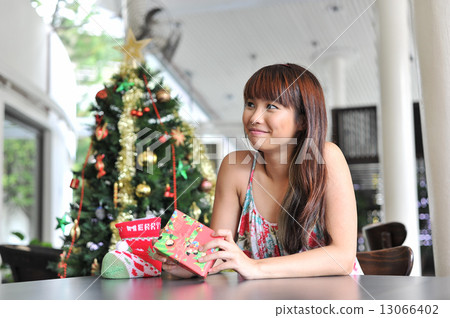 Portrait of a young and beautiful lady waiting at cafe for friends to celebrate christmas together 13066402
