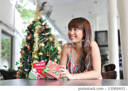 Portrait of a young and beautiful lady waiting at cafe for friends to celebrate christmas together 13066403