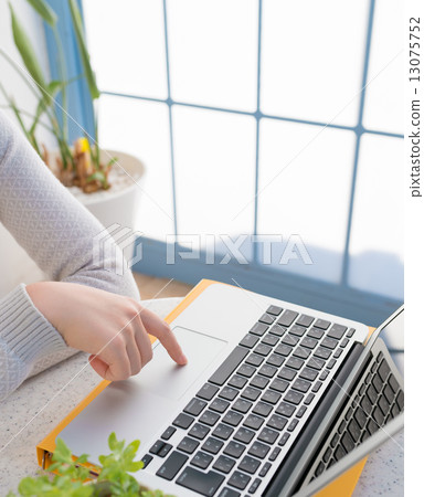 A woman who plays a personal computer 13075752