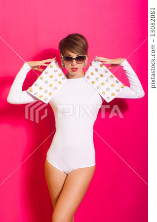 Beautiful girl in a white concert suit on pink background Beautiful girl in a white concert suit on pink background 13082081