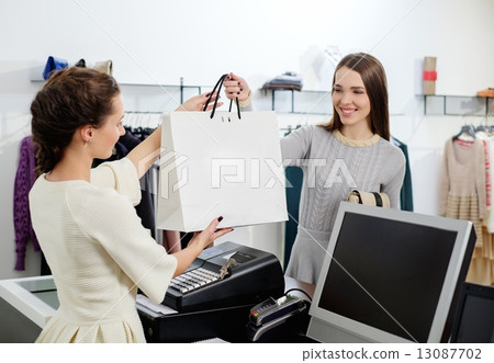 Happy customer with shopping bag in fashion showroom Happy customer with shopping bag in fashion showroom 13087702