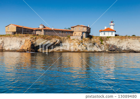 Lighthouse and old wooden buildings on Island 13089480