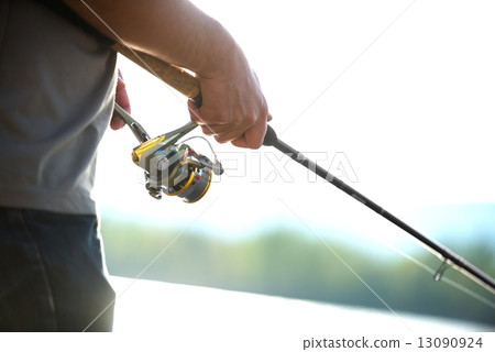 Modern clean fishing rod in hands Modern clean fishing rod in hands 13090924