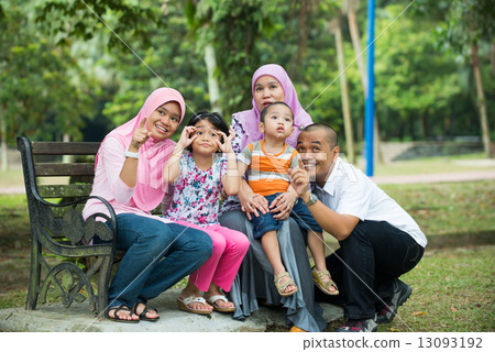 malay muslim family having fun playing in the park 13093192