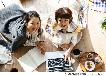 Two ladies watching laptop computers 13106632