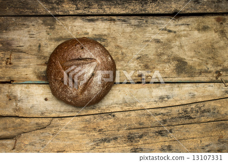 Loaf of rye bread on old wooden table. 13107331