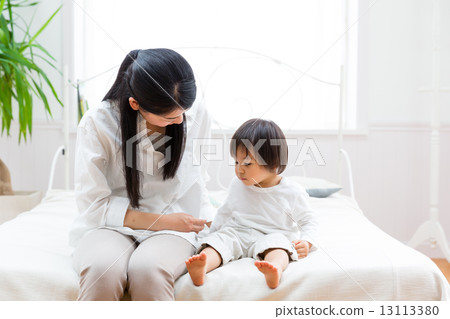 放鬆在床上的嬰孩和母親 放鬆在床上的嬰孩和母親 13113380