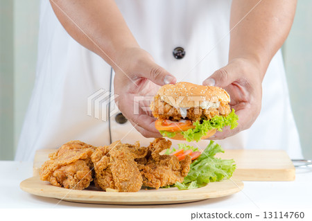 chef holding fried chicken burger 13114760