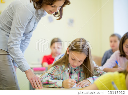 group of school kids writing test in classroom 13117912
