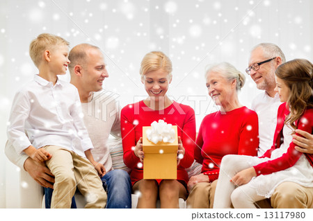 smiling family with gift at home 13117980