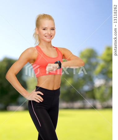 smiling woman with heart rate monitor on hand 13118262