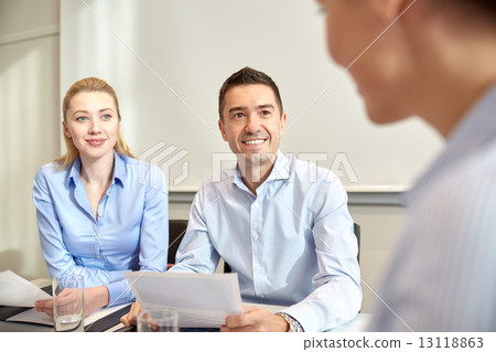 group of smiling businesspeople meeting in office 13118863