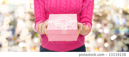 close up of woman in pink sweater holding gift box close up of woman in pink sweater holding gift box 13119138