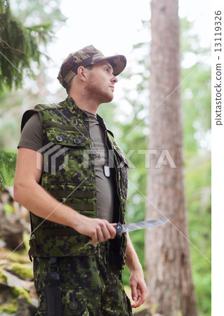 young soldier or hunter with knife in forest 13119326