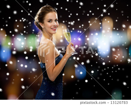 smiling woman holding glass of sparkling wine 13120783