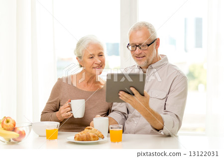 happy senior couple with tablet pc at home happy senior couple with tablet pc at home 13122031