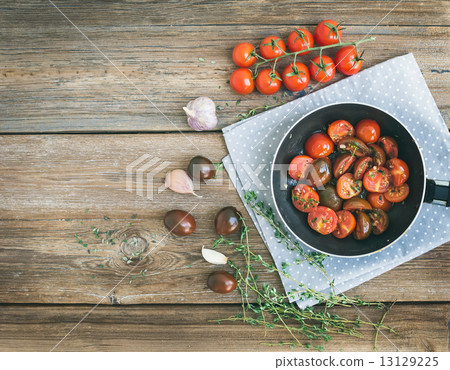 Roasted cherry-tomatoes with garlic and thyme in a cooking pan o 13129225