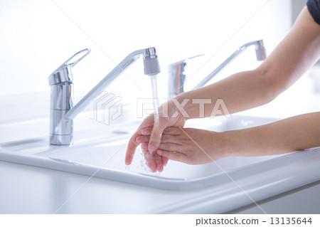 A woman washing her hands 13135644