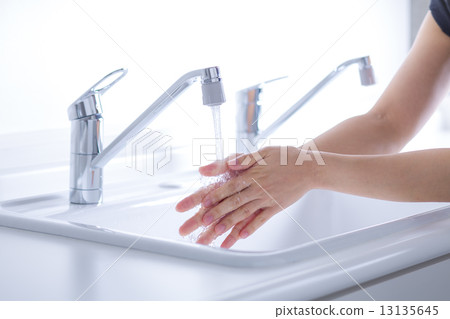 A woman washing her hands 13135645