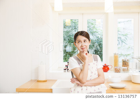 A woman standing in the kitchen A woman standing in the kitchen 13136757