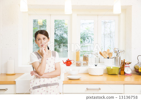 A woman standing in the kitchen A woman standing in the kitchen 13136758