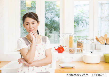 A woman standing in the kitchen A woman standing in the kitchen 13136759