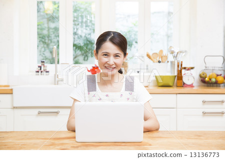 經營個人電腦的中年婦女 經營個人電腦的中年婦女 13136773