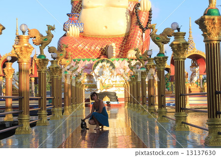 Woman at Smiling fat Buddha of wealth statue on Koh Samui, Thailand Woman at Smiling fat Buddha of wealth statue on Koh Samui, Thailand 13137630