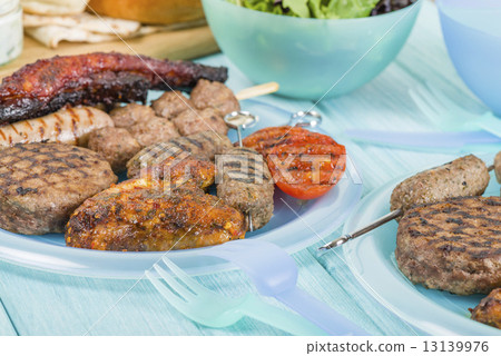 BBQ - Assorted barbequed meat and bread on a blue background.  13139976