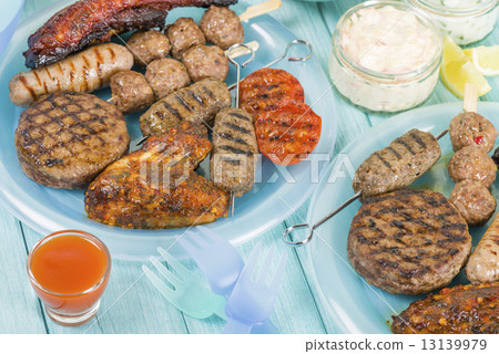 BBQ - Assorted barbequed meat and bread on a blue background.  13139979