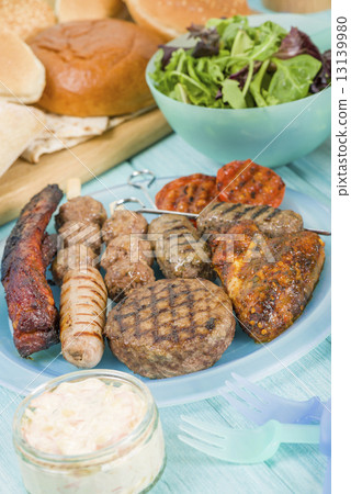 BBQ - Assorted barbequed meat and bread on a blue background.  13139980