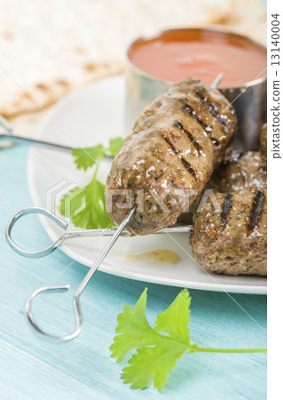 Seekh Kebab - Grilled spiced lamb mince on a metal skewers served with chili sauce and lemon wedges  13140004