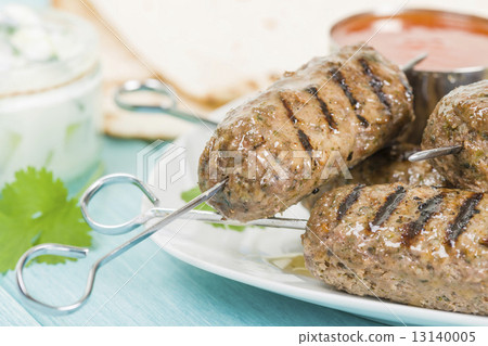 Seekh Kebab - Grilled spiced lamb mince on a metal skewers served with chili sauce and lemon wedges  13140005